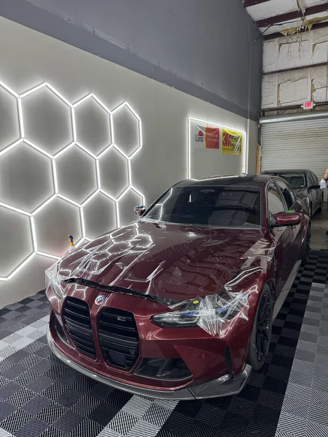 Red BMW performance sedan having paint protection film fitted to the hood and front end in Alpharetta, GA