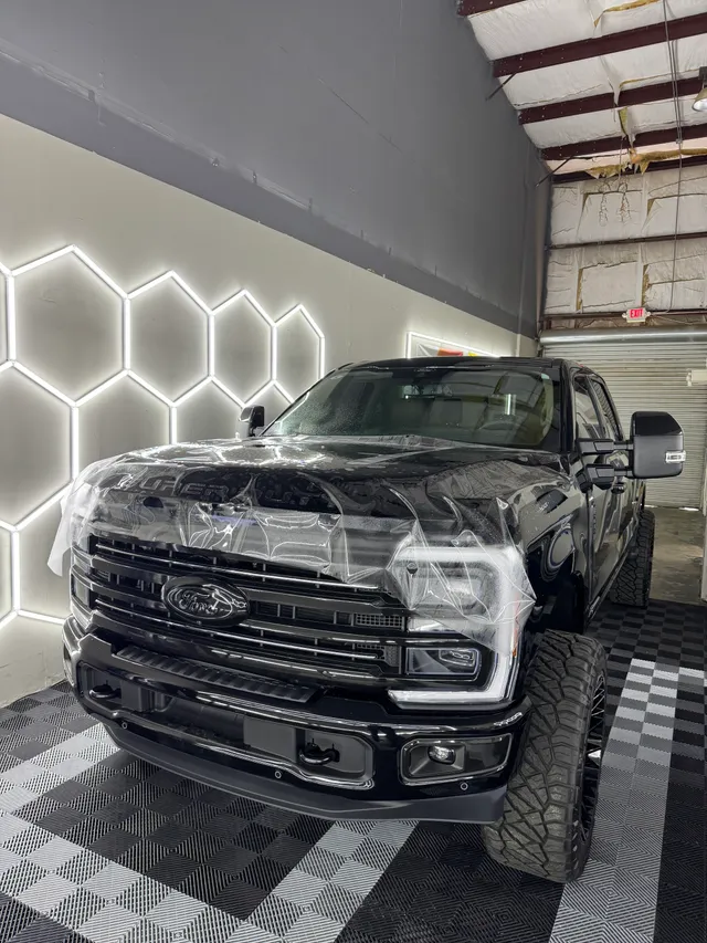 Black lifted Ford Super Duty having paint protection film fitted to the hood and front end in Alpharetta, GA