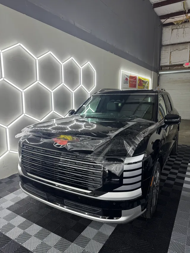 Black full-size SUV having paint protection film fitted to the hood and front end in Alpharetta, GA